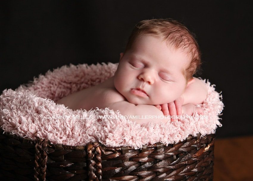 Baby girl sleeping in basket for newborn portraits in Pickering