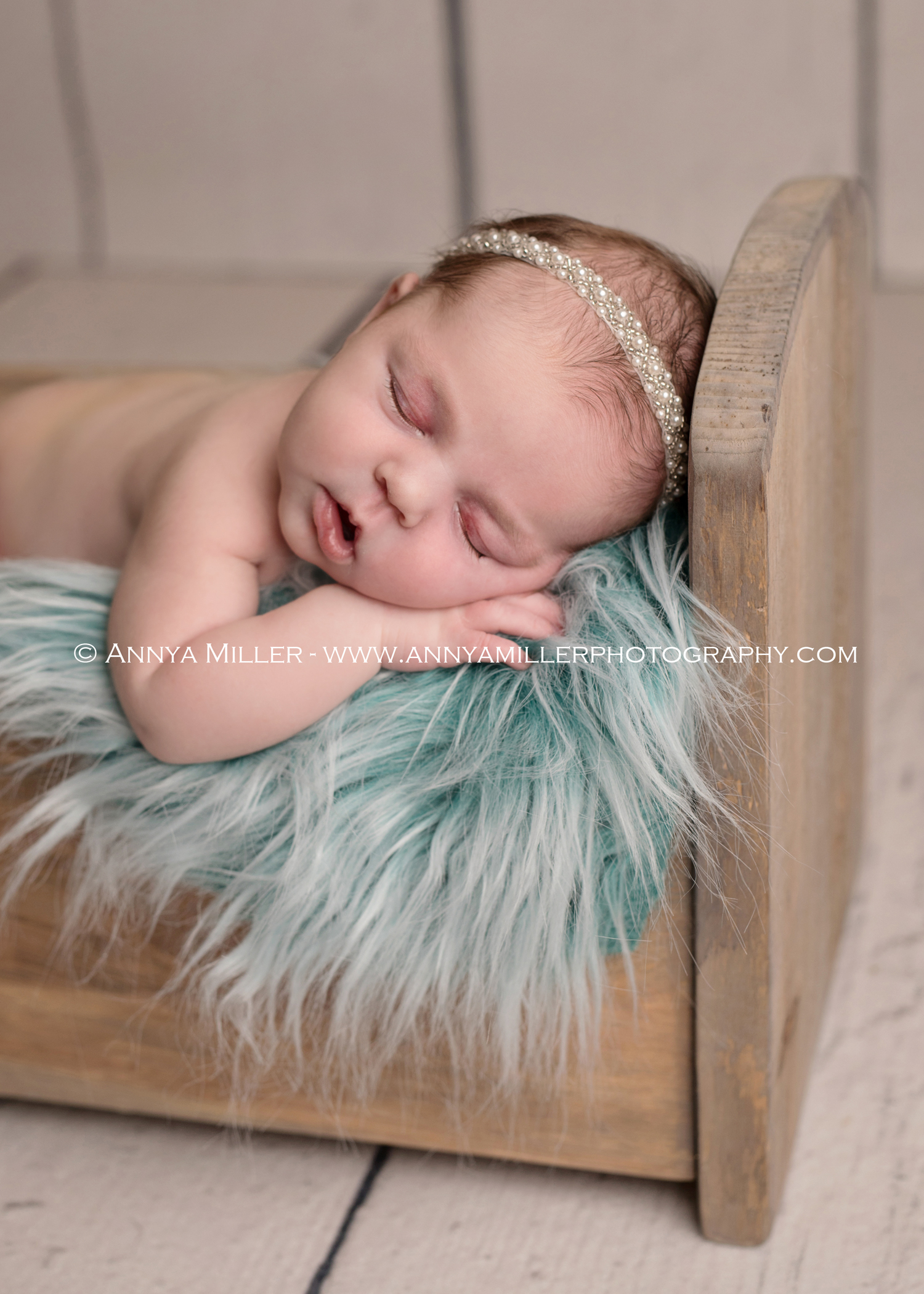 Portrait of newborn girl in wooden bed by toronto newborn photographer Annya Miller 