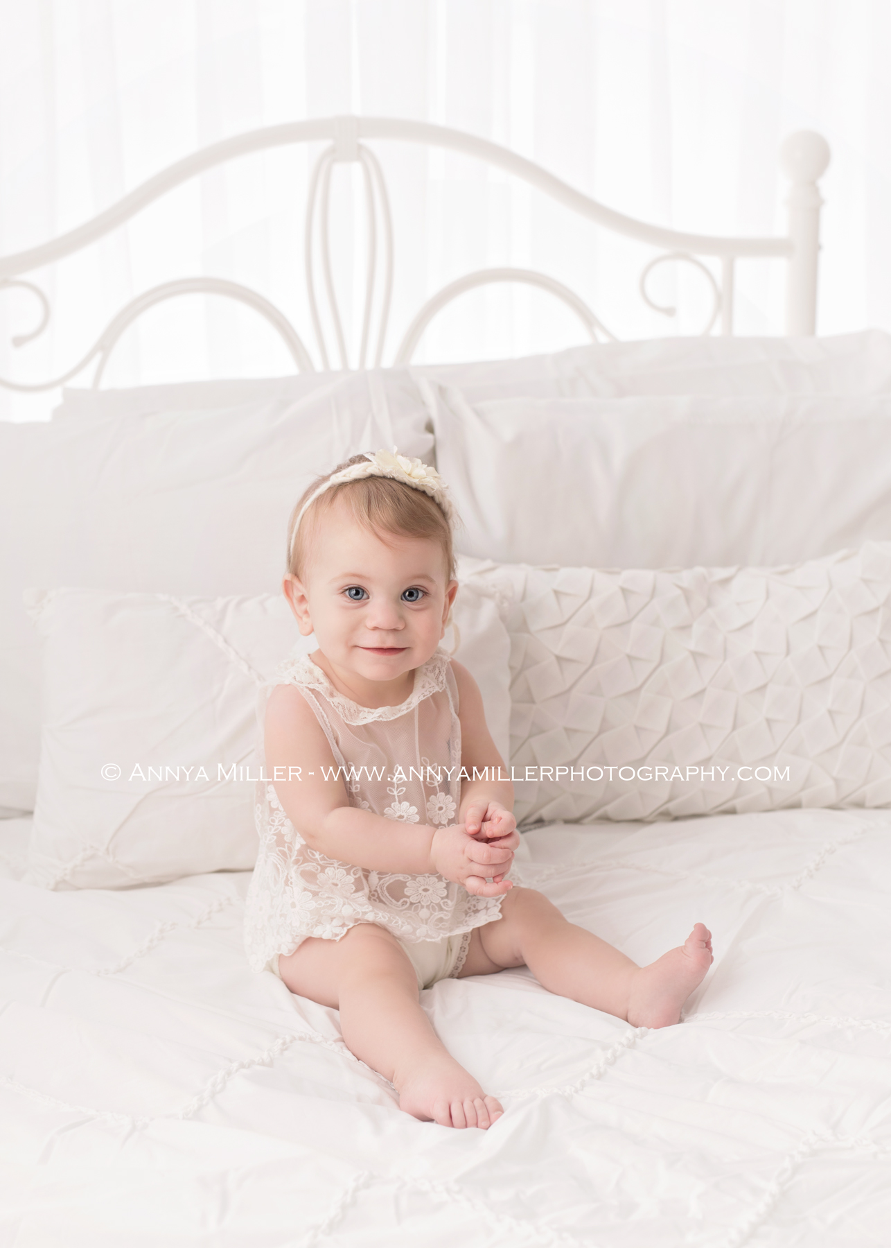 Photograph of baby girl on a white bed by Pickering photographer Annya Miller 