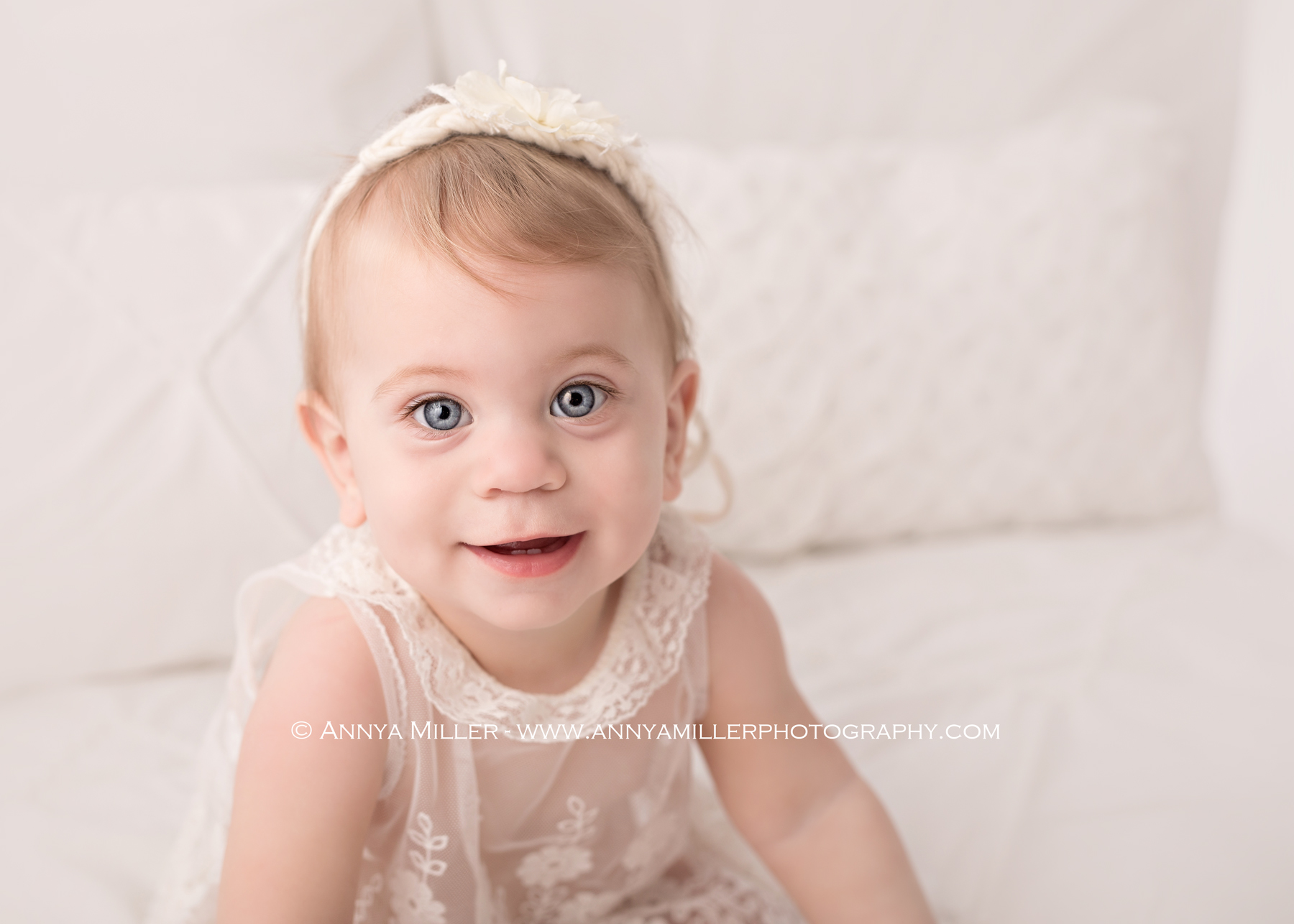 Photograph of baby girl on a white bed by Pickering photographer Annya Miller