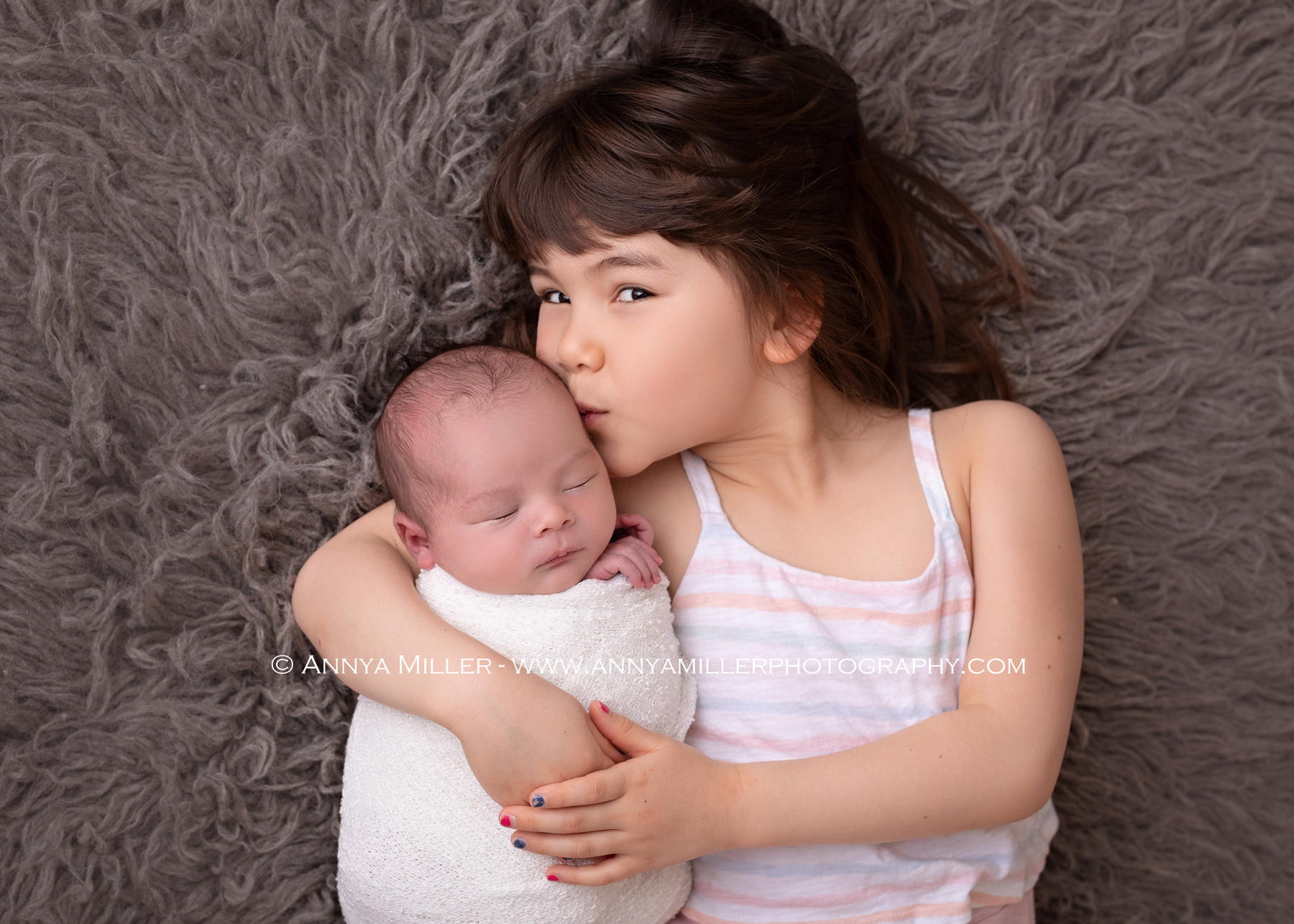 Older sister kissing her baby brother in durham newborn photos