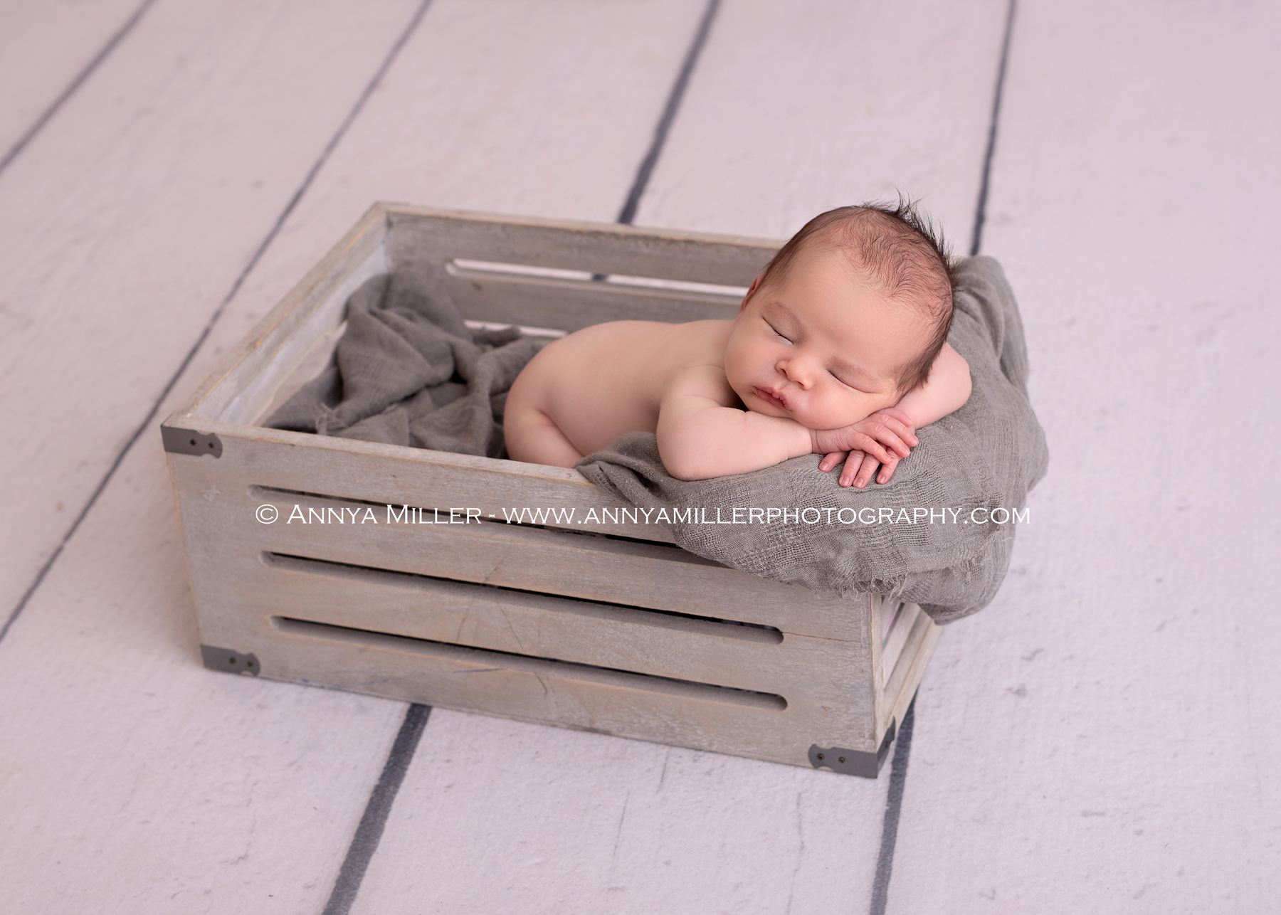 Newborn boy sleeping in crate in Durham newborn photos 
