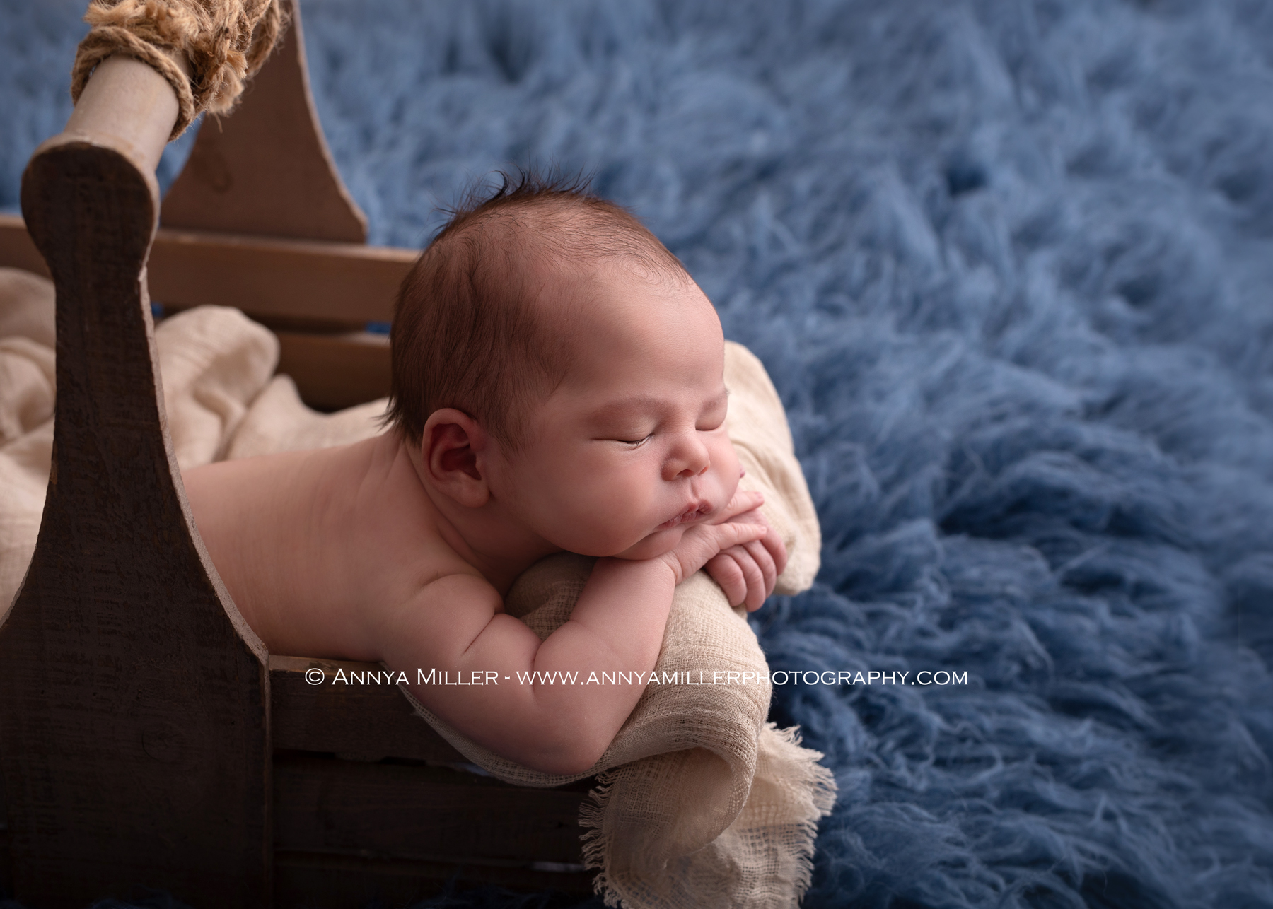 Newborn boy sleeping in crate in durham newborn photos 