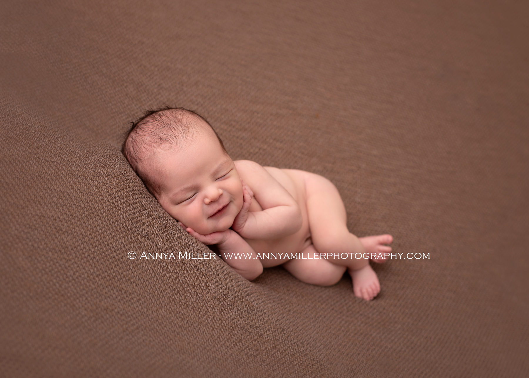 Baby boy sleeping on blanket and smiling in Durham newborn photos