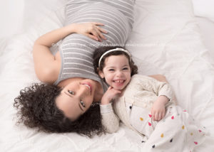pregnancy portraits of Mom and daughter on white bed by durham region maternity photographer Annya Miller