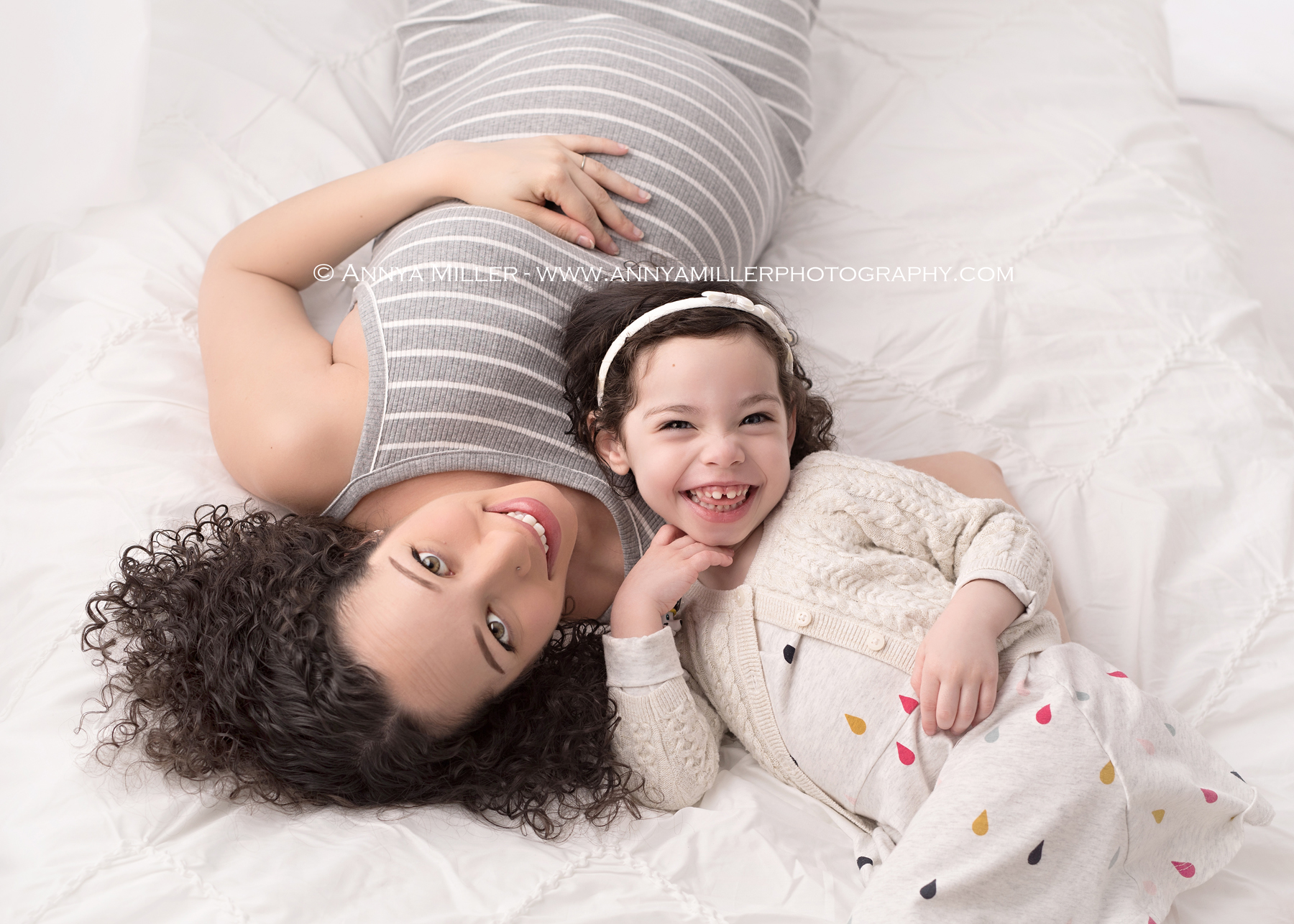 pregnancy portraits of Mom and daughter on white bed by durham region maternity photographer Annya Miller 