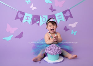 1st birthday photos of baby girl on teal and purple butterfly set at her Pickering cake smash session by Annya Miller Photography