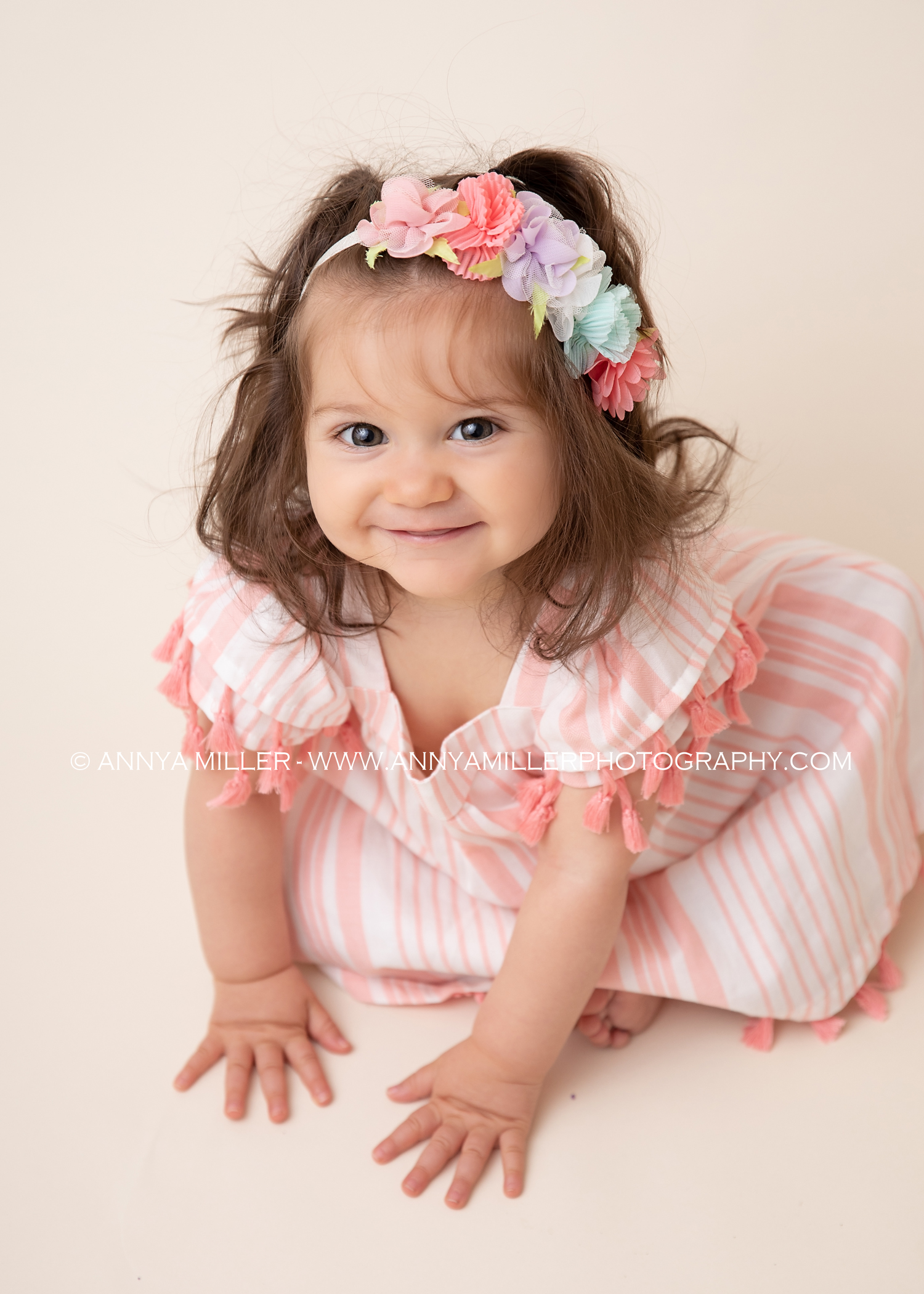 First birthday portraits of baby girl in pink and floral headband by GTA cake smash photographer Annya Miller 
