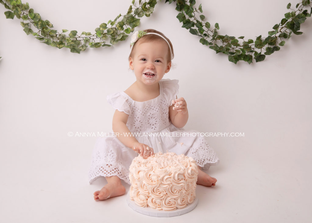 Baby girl on boho set enjoying cake at Pickering cake smash session by Annya Miller Photography