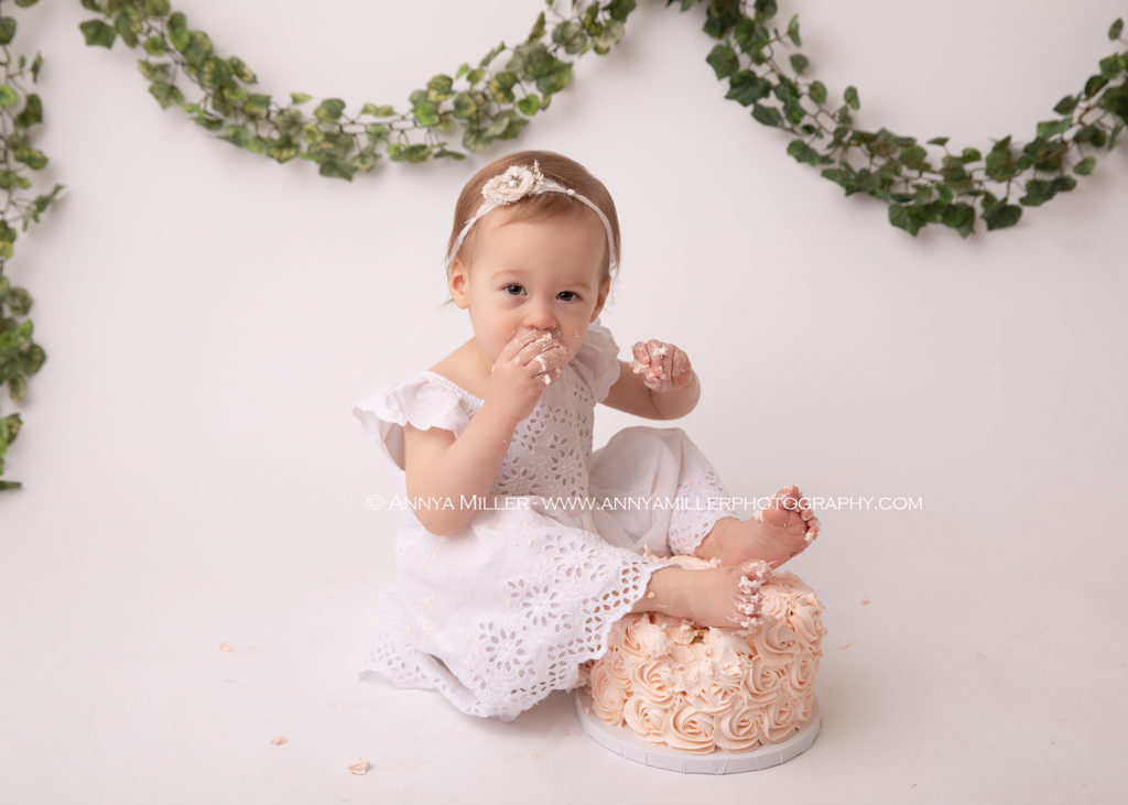 Baby girl on boho set enjoying cake at Pickering cake smash session by Annya Miller Photography