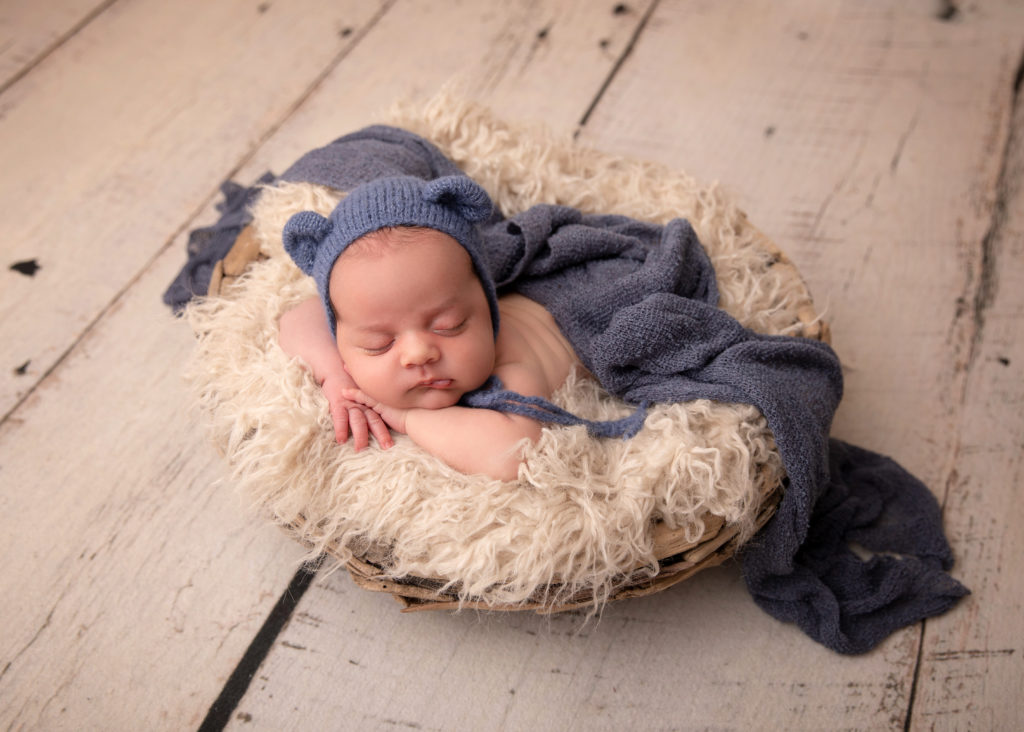 New baby boy posed in basket with bear hat by Durham Region newborn Photographer Annya Miller of Pickering. 