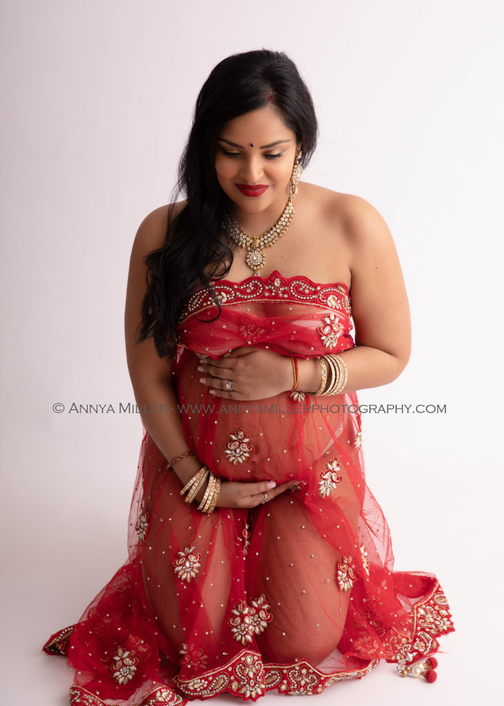pregnancy photoshoot of woman in red sari